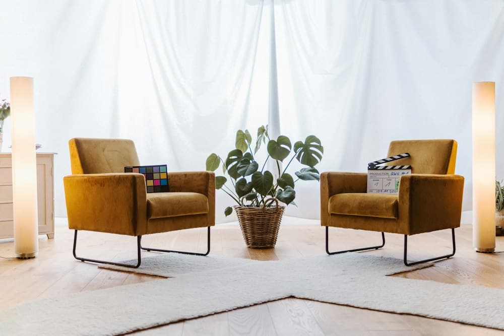 Sala de atendimento com duas poltronas amarelas e uma planta entre elas